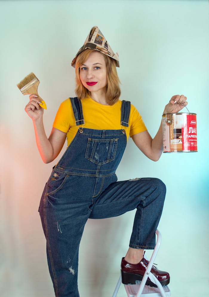 Smiling woman holding paintbrush and can, preparing to decorate.